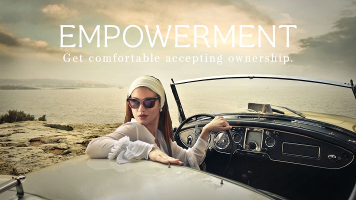 attractive woman at the wheel of a convertible car on the coastline showing empowerment